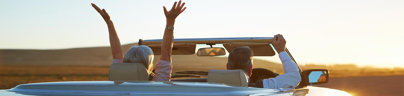 Mature couple in convertible car on open road