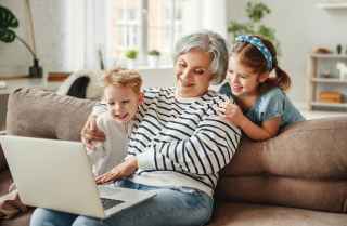  Grandmother with kids watching images on laptop.