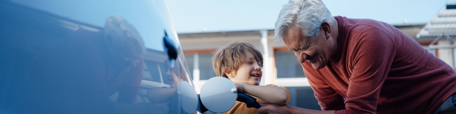 A boy with his Grandfather with their car