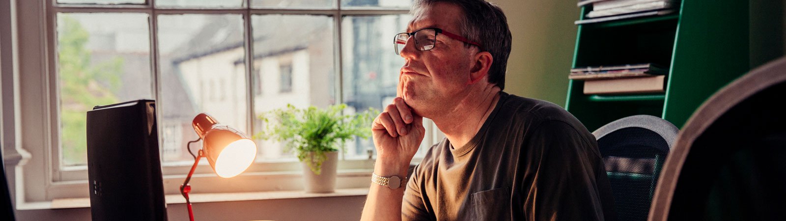 man in front of computer with lamp