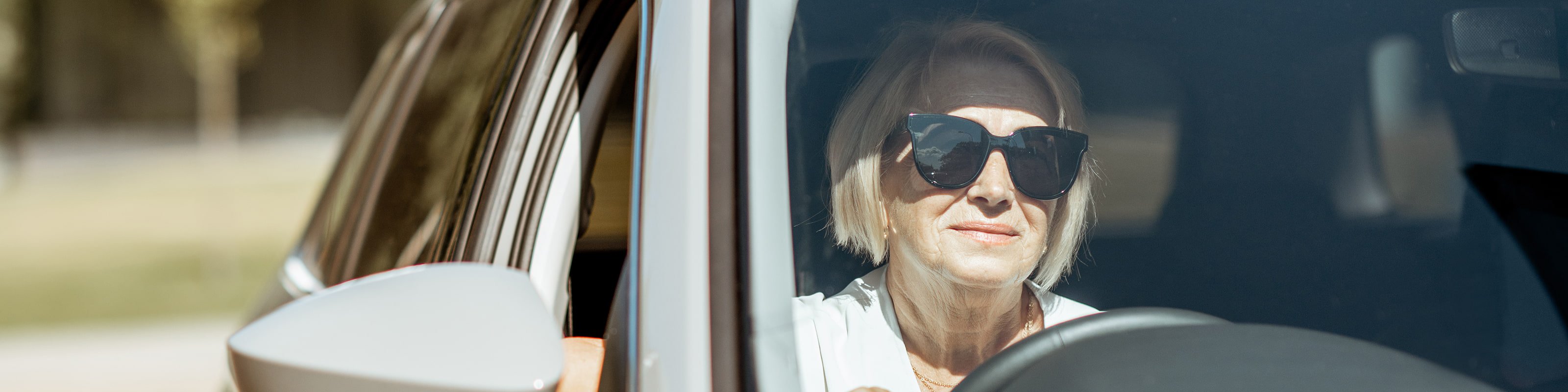 Woman driving car wearing sunglasses