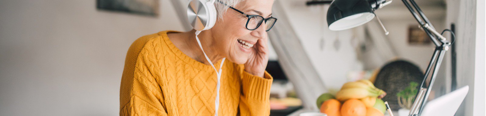 Woman in headphones working at laptop computer