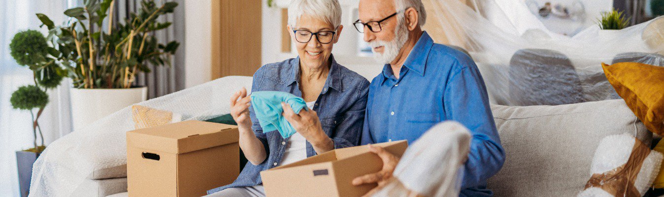 woman and man on couch putting items into boxes