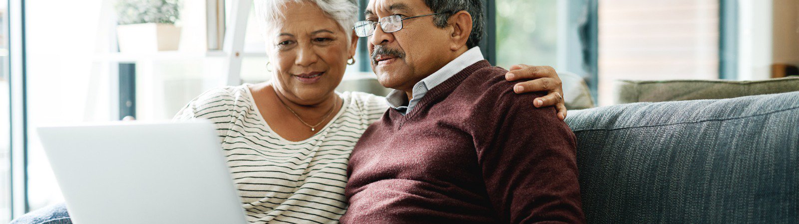 Elderly couple using laptop at home 