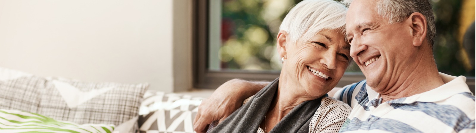 Mature man and woman smiling on couch