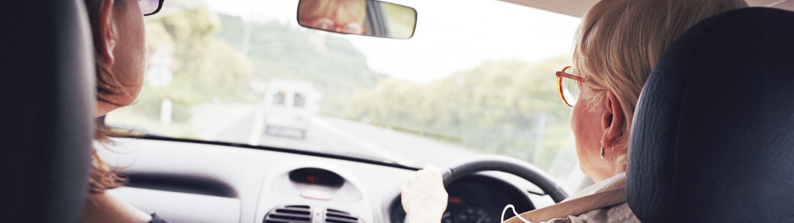 Mature woman drives car with passenger