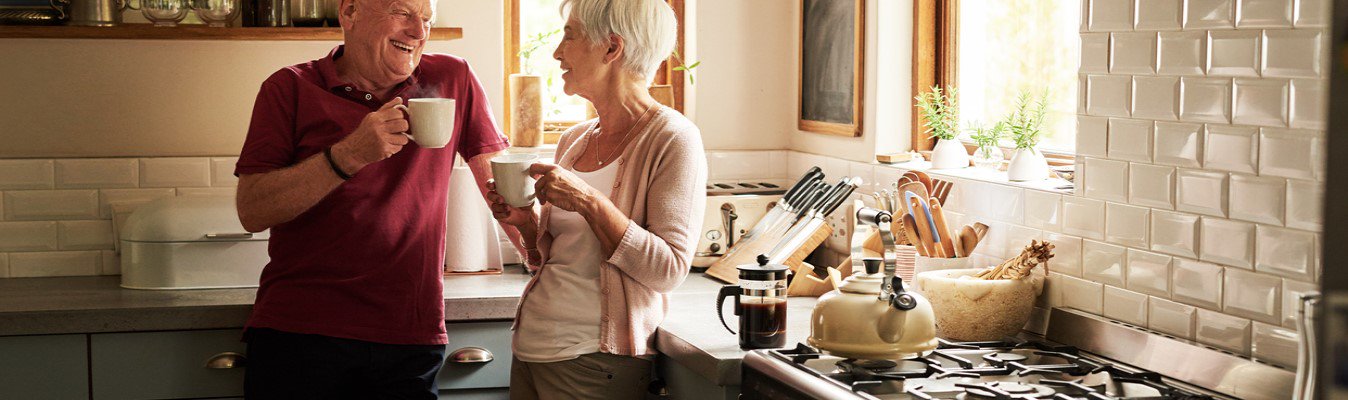 senior man and woman drinking coffee at home