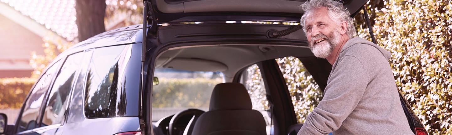 man loading surfboard in car